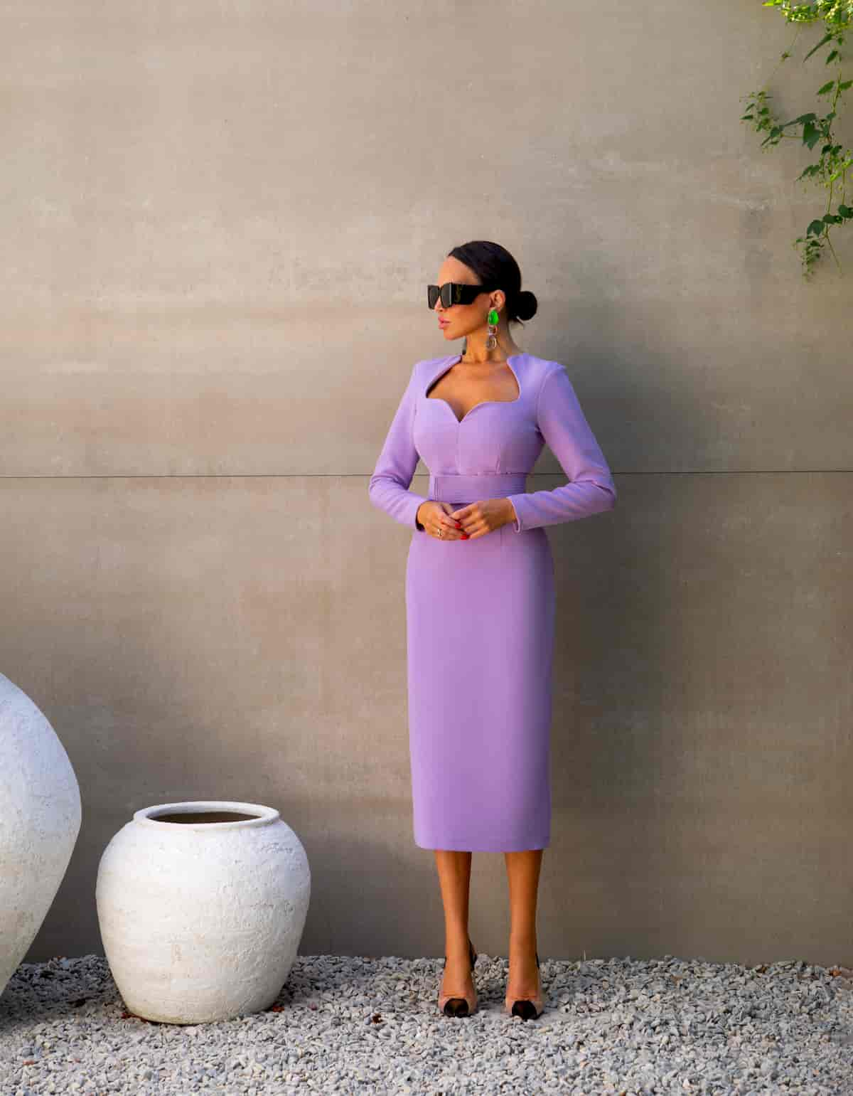 A dress of lilac color with a curved neckline and a belt